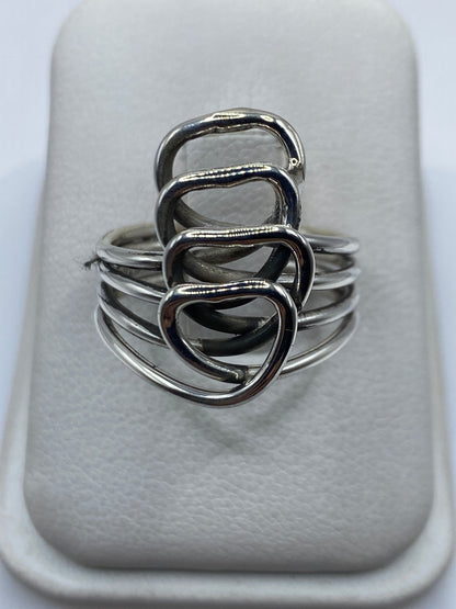 Anillo de plata calado con cuatro corazones entrelazados en mano de mujer