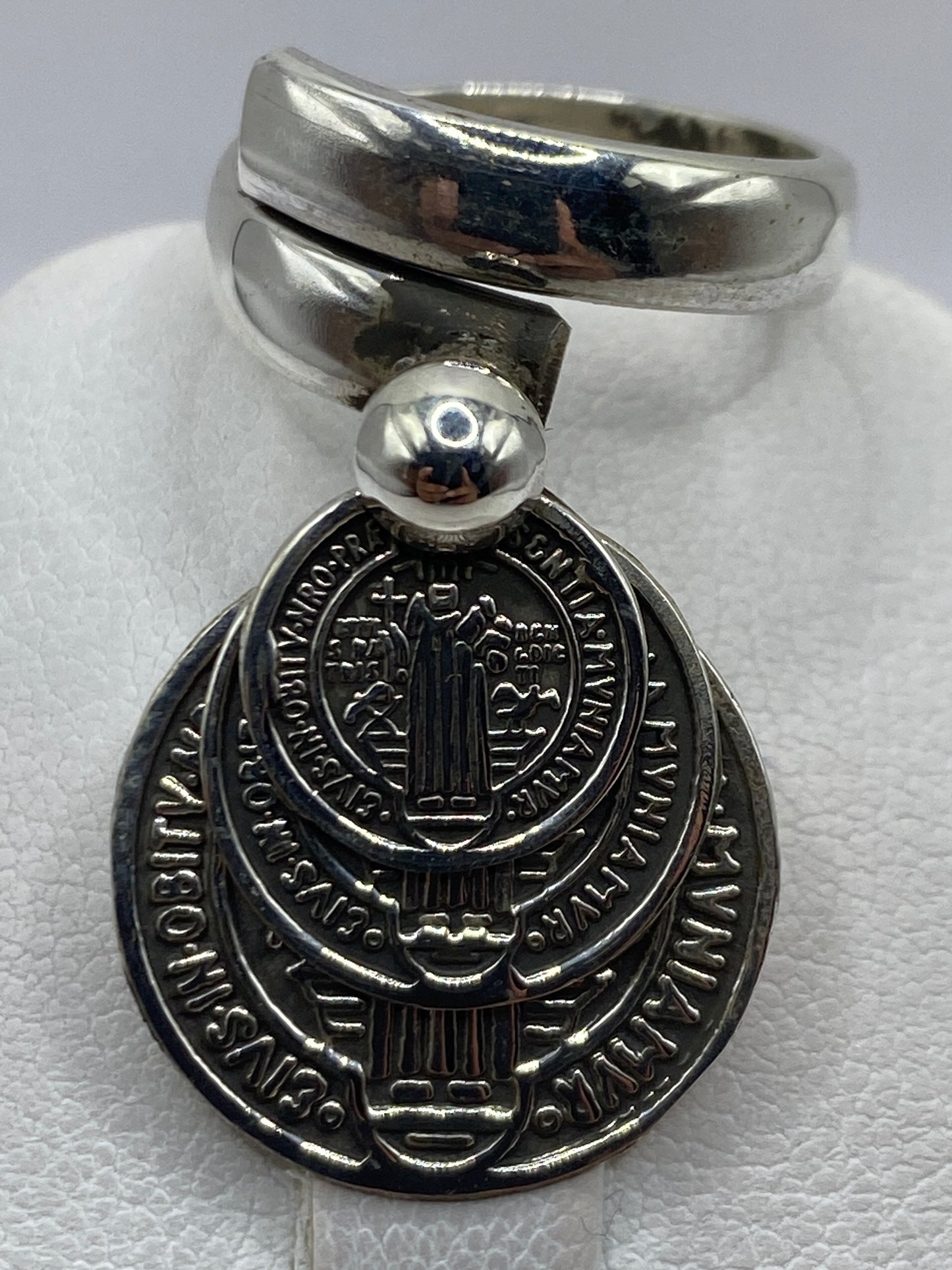 Detalle de las tres medallas de San Benito grabadas en la plata