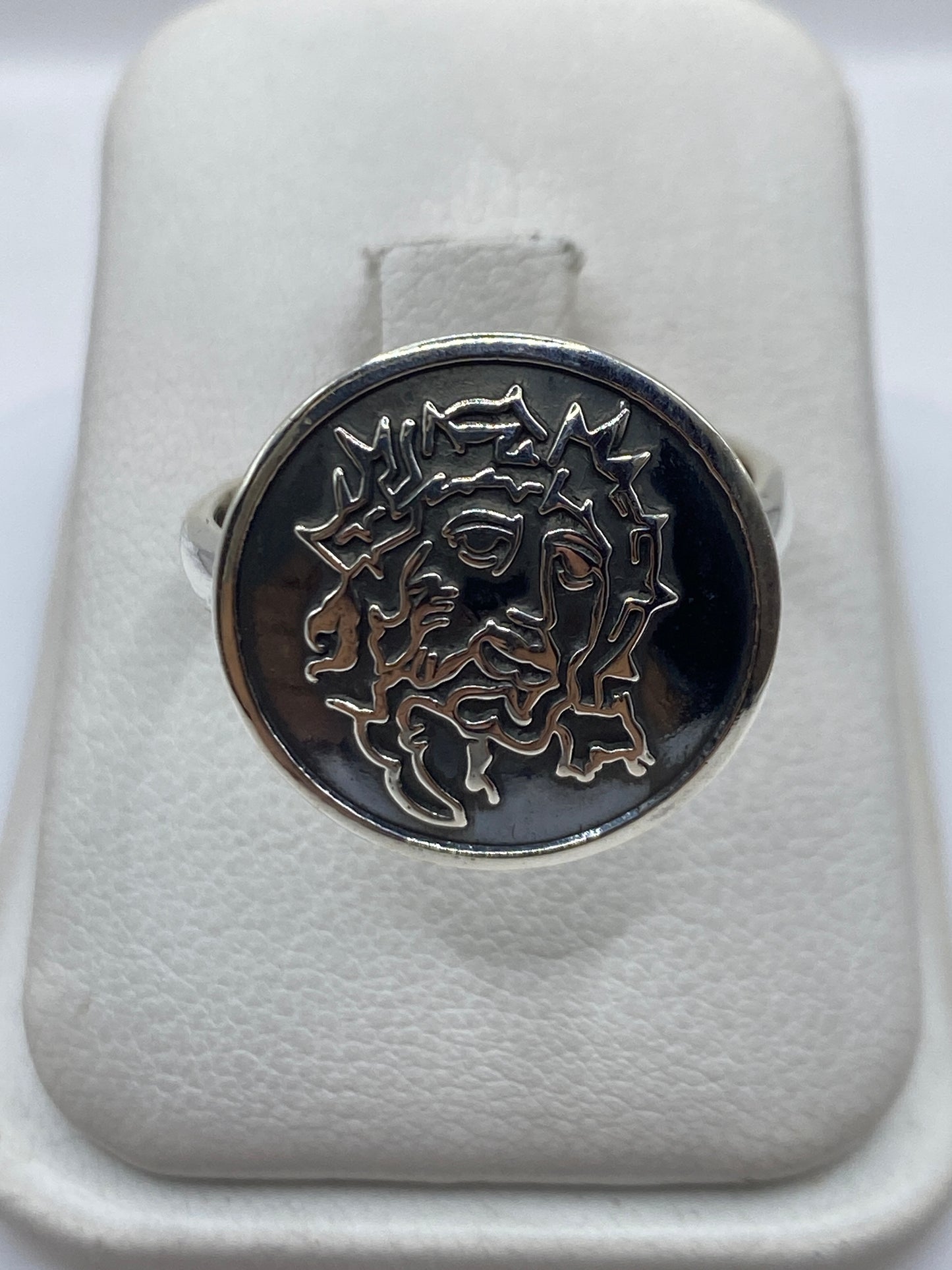 Anillo de sello en plata .925 sobre fondo blanco mostrando el relieve del rostro