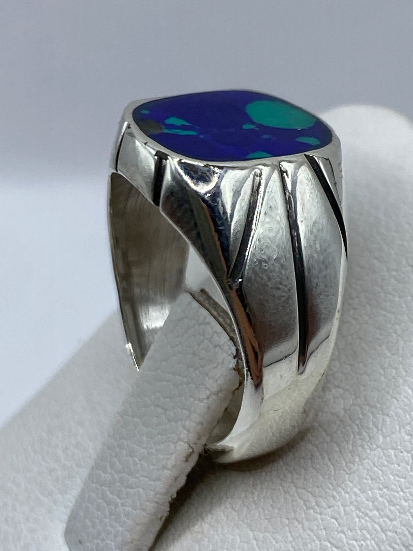 Anillo en dedo de mujer, piedra azul brillante sobre plata bruñida