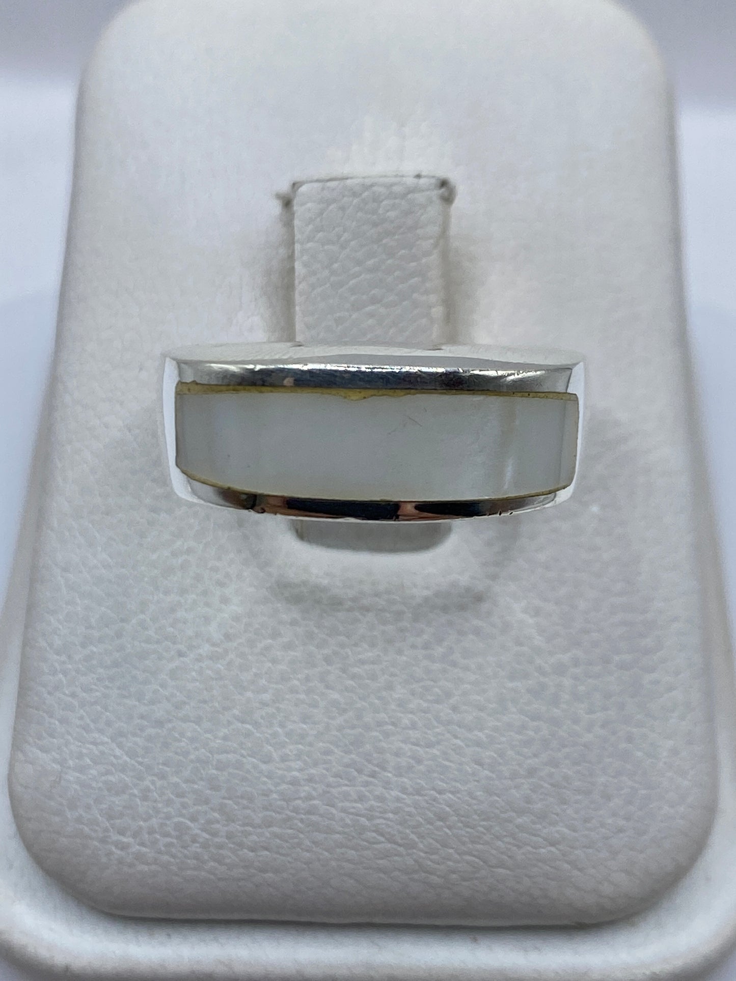 Anillo de plata con perla blanca redonda engastada en el centro, vista frontal