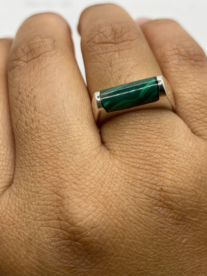 Anillo en dedo mostrando el color verde profundo de la malaquita bajo luz natural