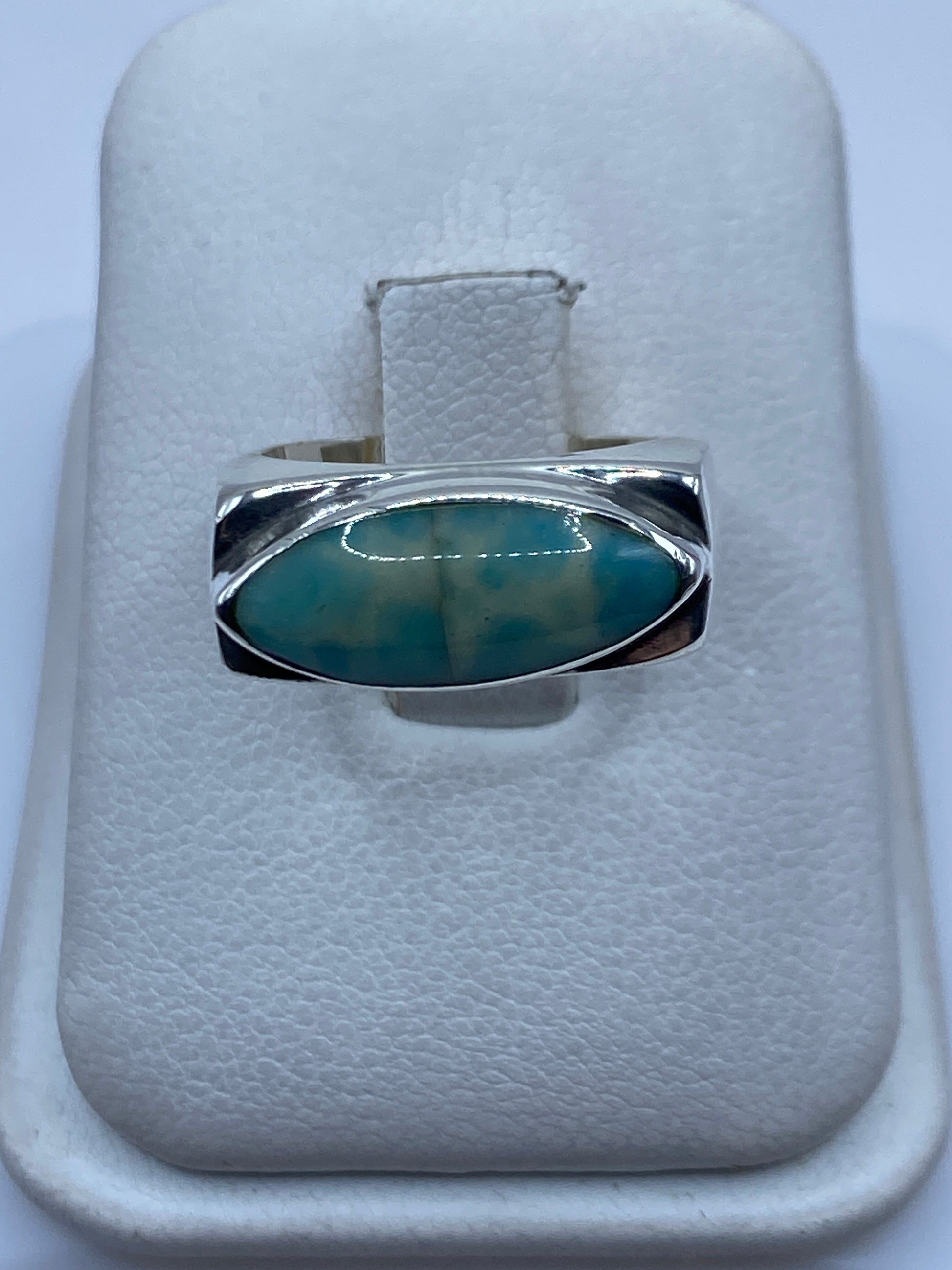 Anillo de plata con piedra azul cielo engastada a mano, vista frontal en estuche blanco