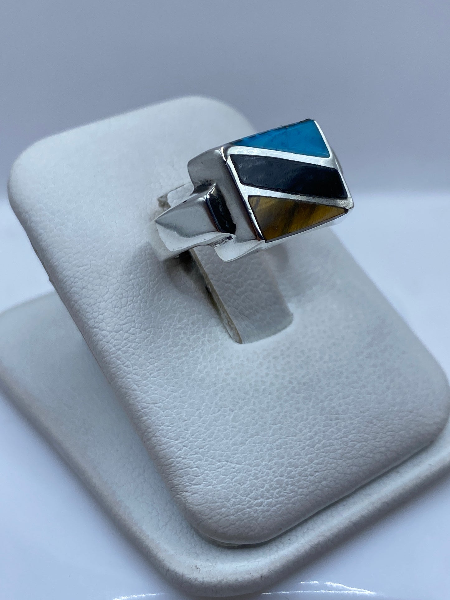 Anillo de turquesa en la mano de una persona, mostrando el color azul cielo y el engaste de plata