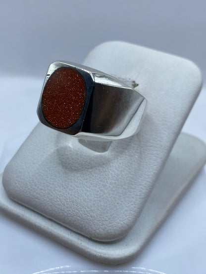 Detalle lateral del anillo unisex mostrando el engaste de la piedra y la plata pulida