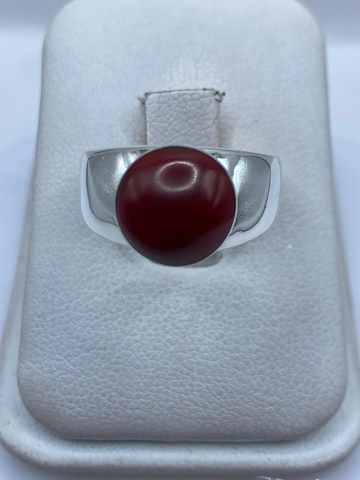 Anillo de plata .925 con coral rojo natural engastado, vista frontal sobre estuche blanco