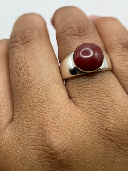 Anillo de plata con coral en el dedo, mostrando el look moderno y versátil