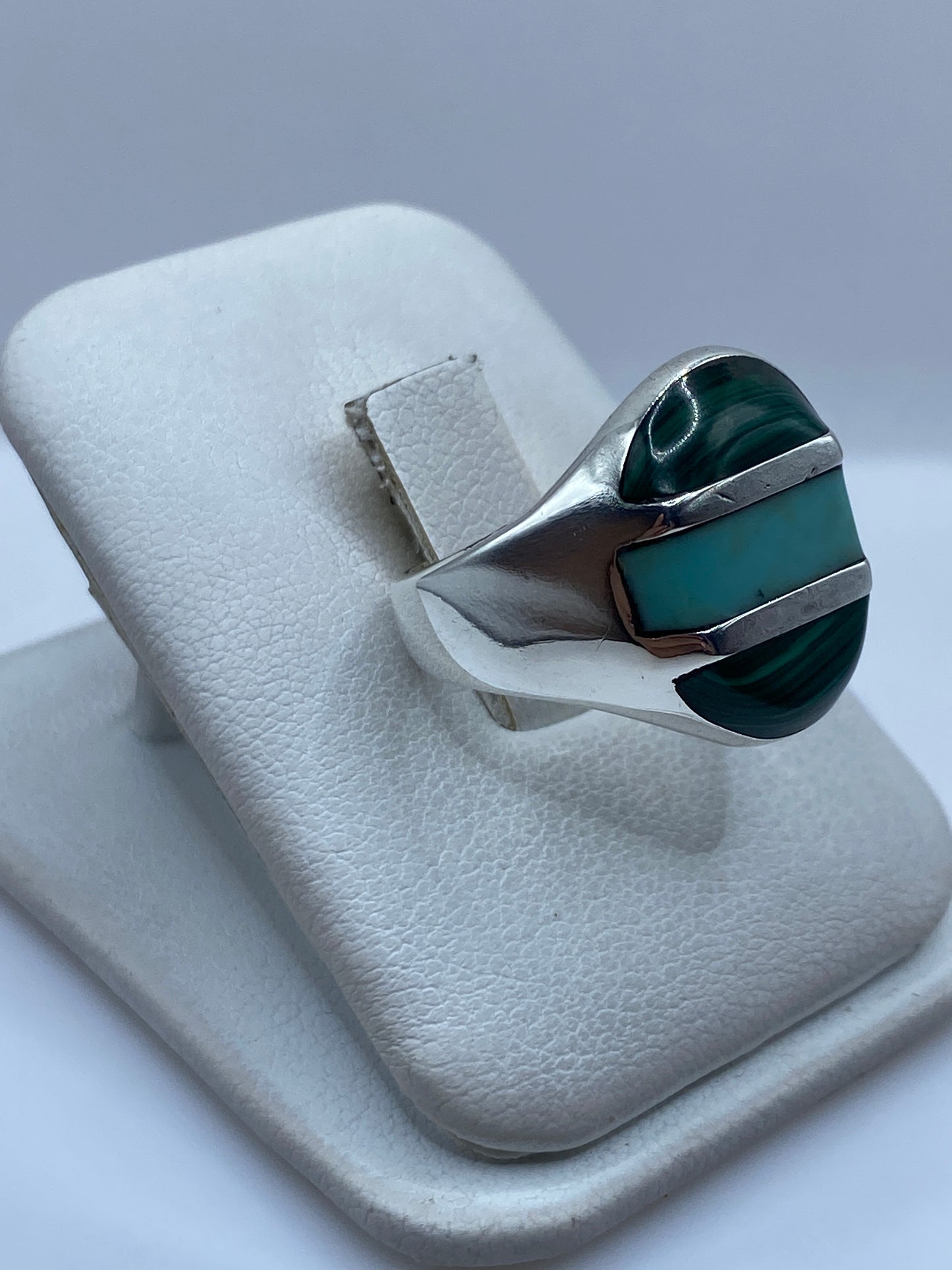 Anillo de plata y malaquita puesto en el dedo, mostrando el verde natural de la piedra