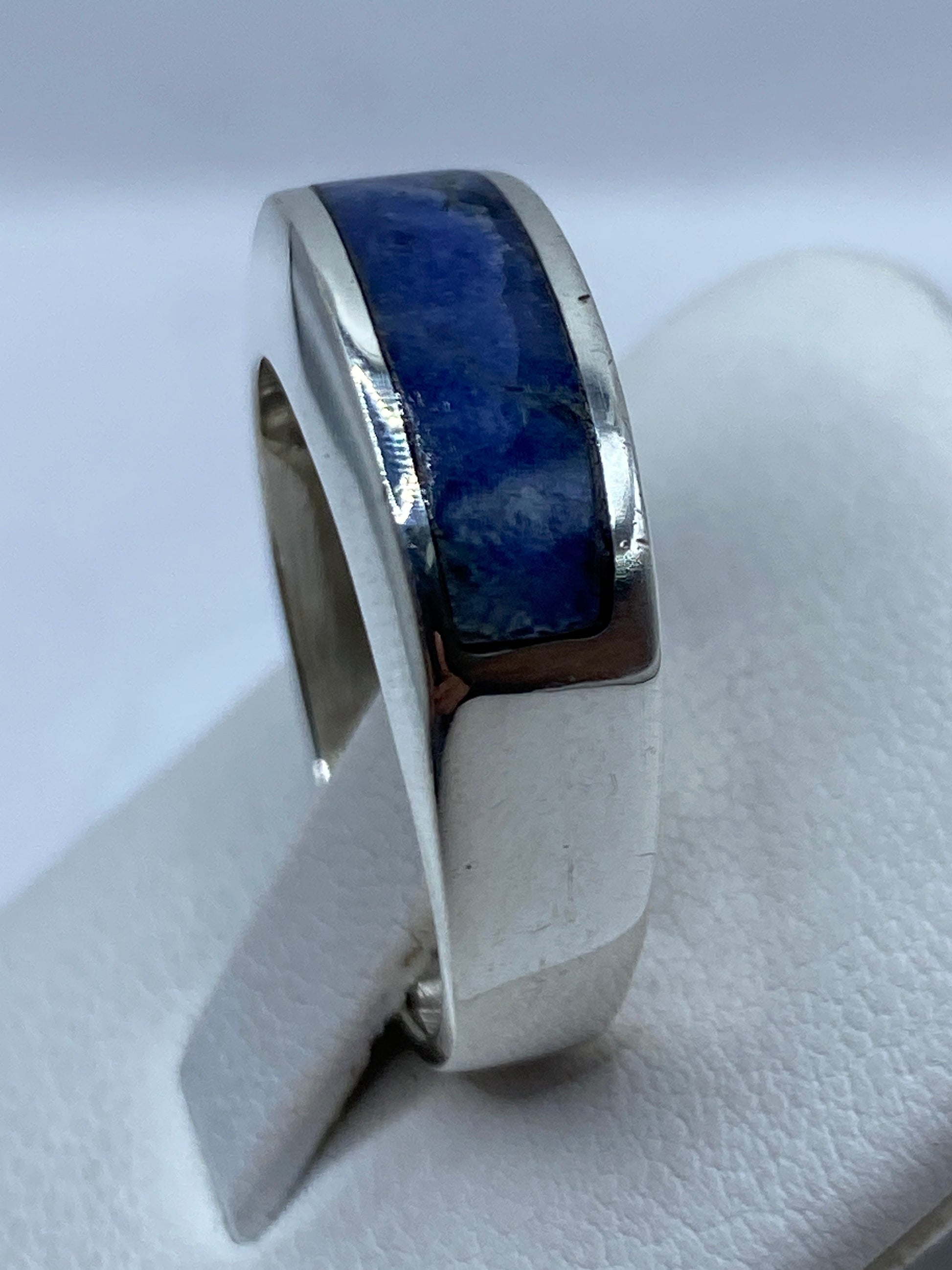 Anillo en la mano mostrando el color azul intenso con vetas doradas
