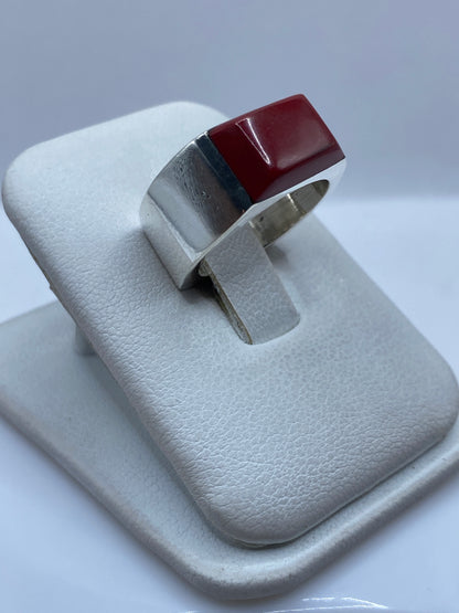 Anillo de plata y piedra roja en la mano, mostrando el engaste detallado
