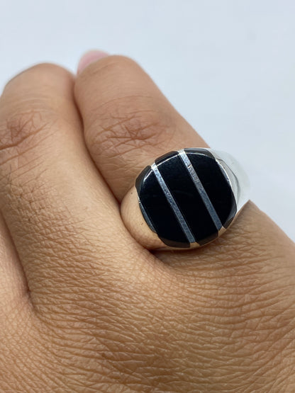 Anillo en la mano mostrando la profundidad del negro del ónix contra la plata .925
