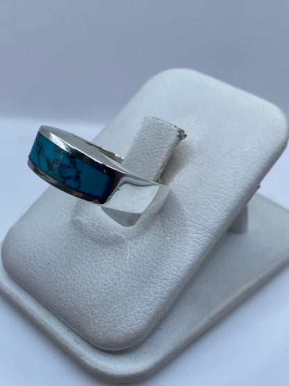 Detalle del engaste a mano de turquesa en la banda de plata, mostrando las vetas negras de la piedra