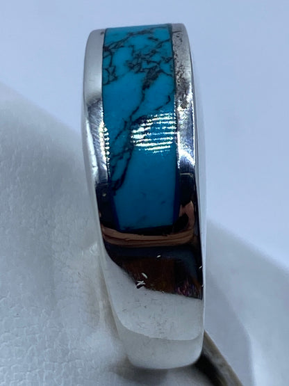 Anillo en dedo, turquesa azul cielo brillando contra la piel, diseño unisex