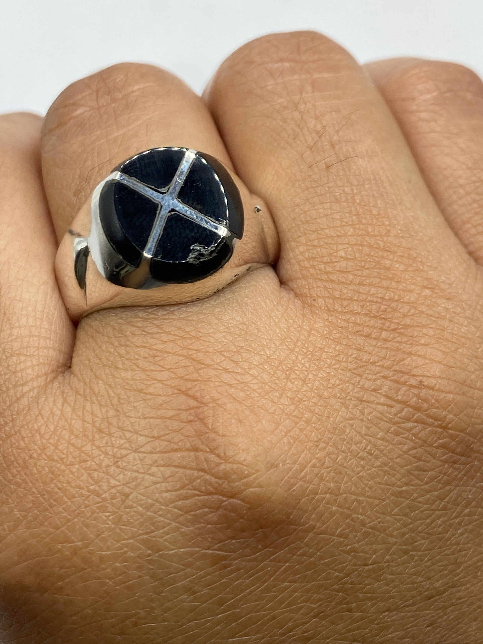 Anillo en dedo, portando el ónix negro sobre fondo neutro mostrando proporciones reales