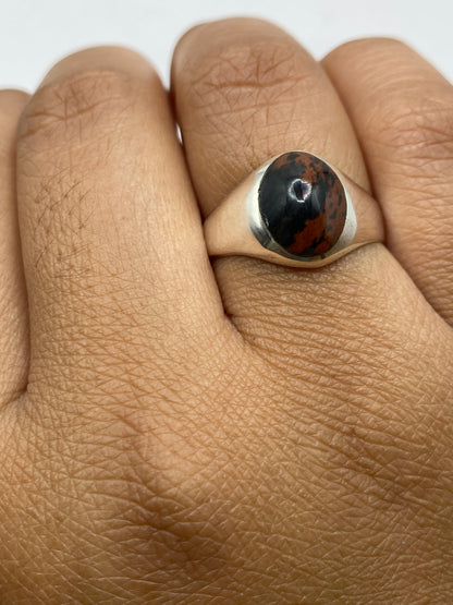 Anillo de plata solitario sobre fondo gris, vista completa del diseño minimalista