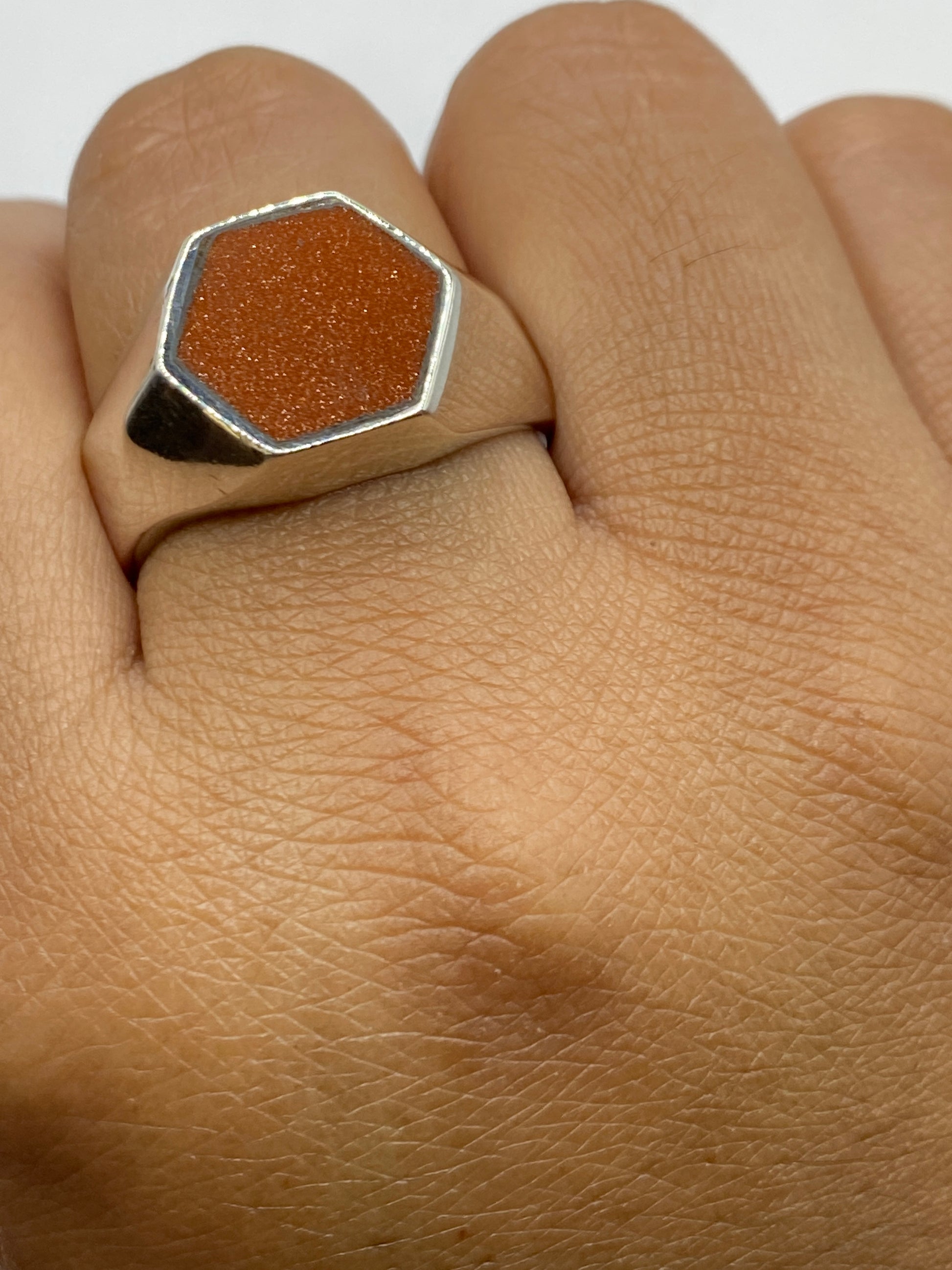 Anillo en dedo masculino mostrando proporción y presencia del sello