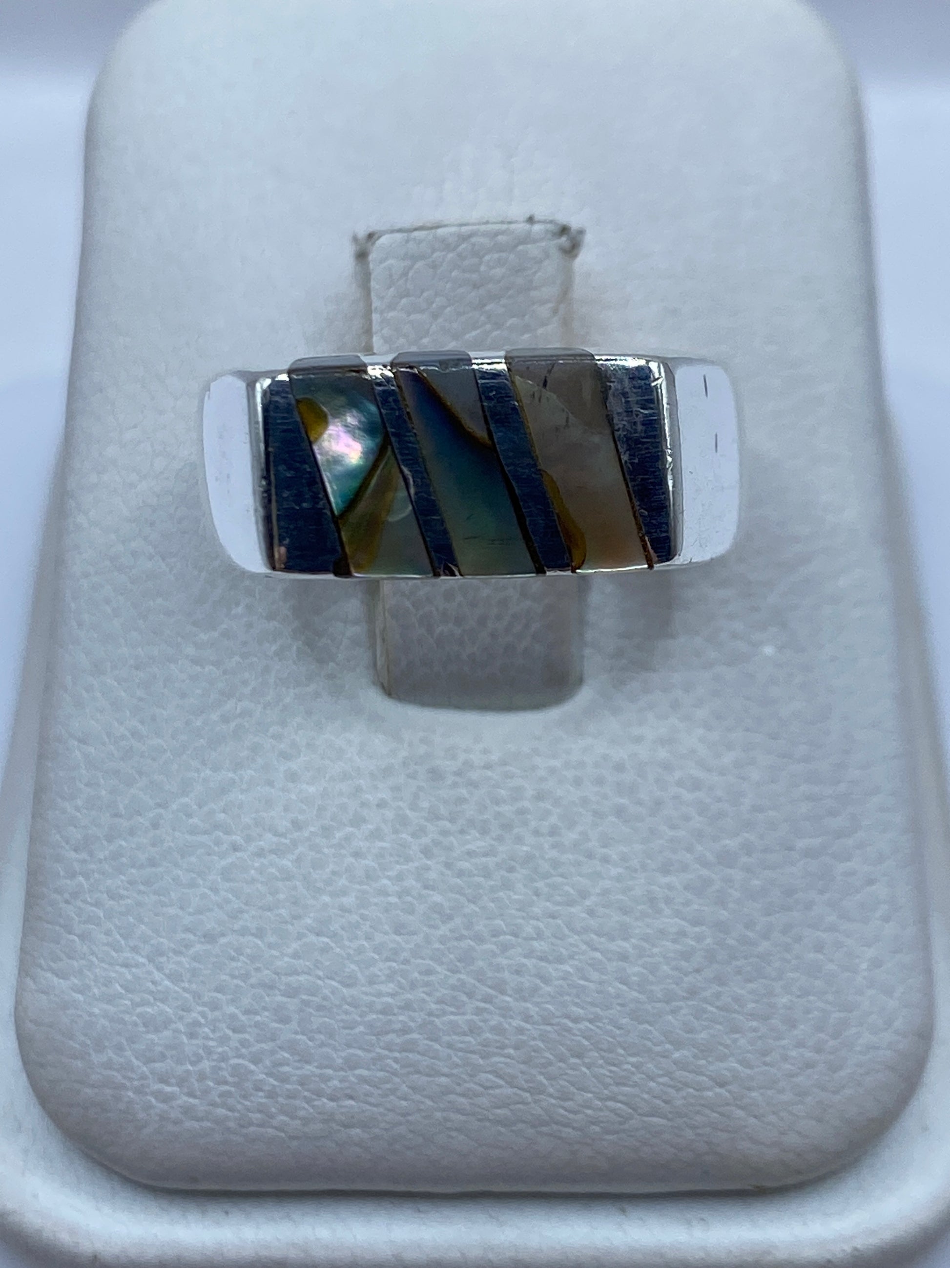 Anillo de plata .925 con piedra engastada en diseño geométrico, visto desde arriba sobre estuche blanco
