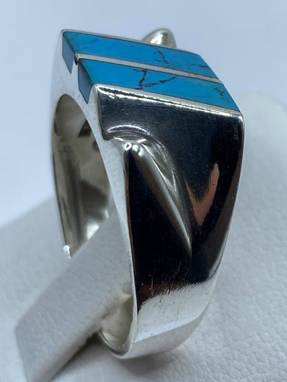 Detalle lateral del anillo de plata con incrustación de turquesa y hombros tallados