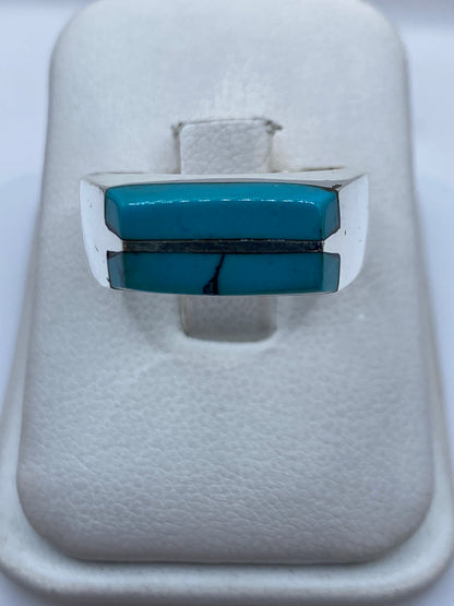 Anillo de plata con turquesa azul cielo engastada en diseño geométrico sobre fondo blanco