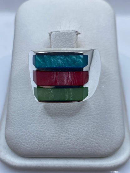 Anillo de plata .950 con bandas de piedras multicolor: turquesa, granate y verde, sobre fondo blanco