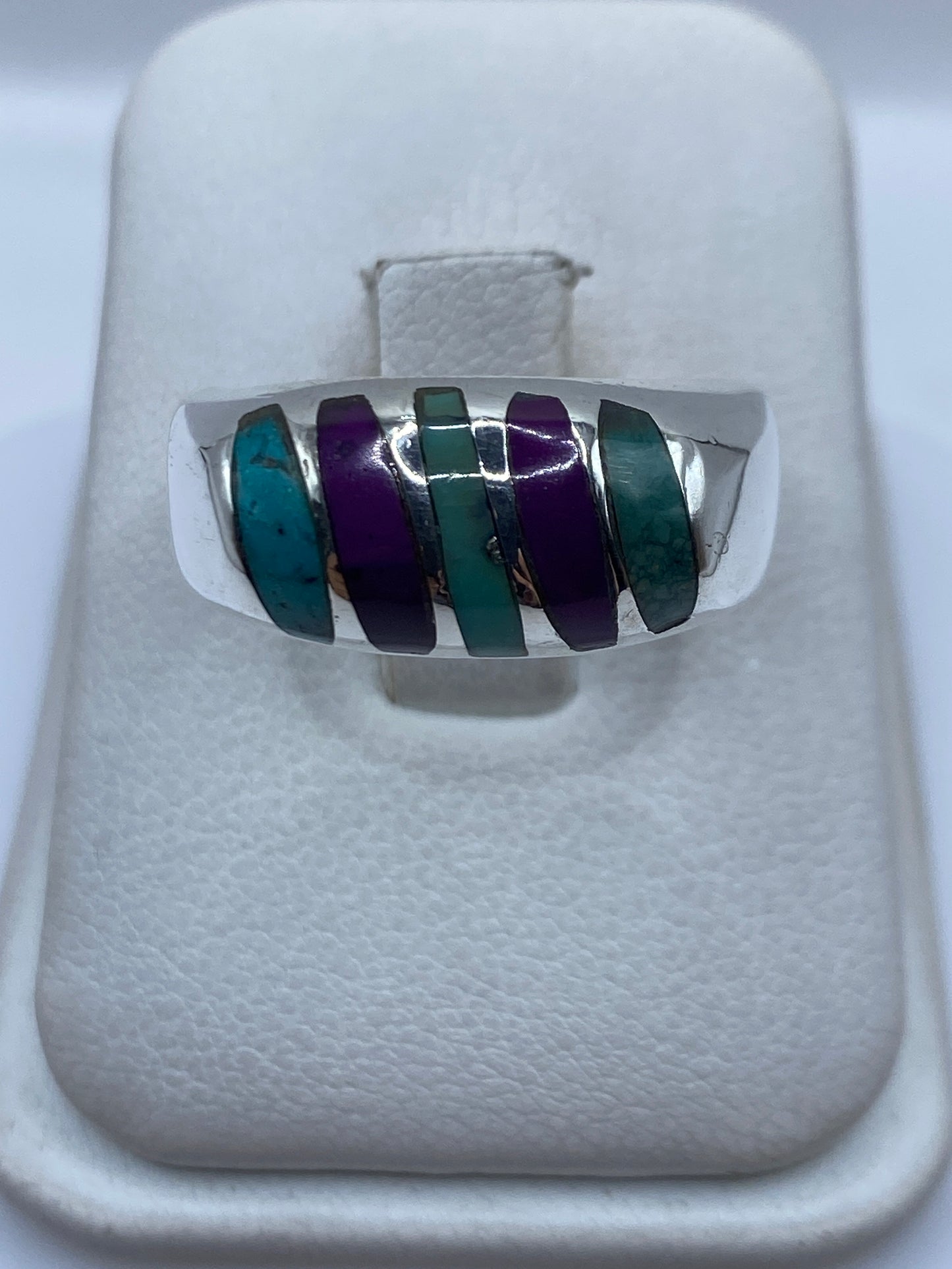Anillo de plata .925 con cinco incrustaciones de turquesa azul cielo separadas por franjas de plata en la mano