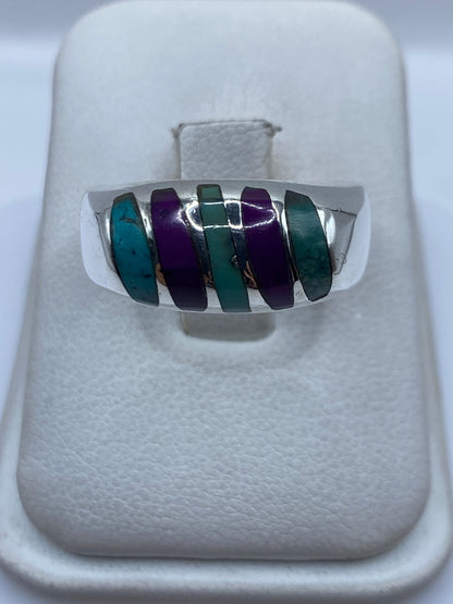 Anillo de plata .925 con cinco incrustaciones de turquesa azul cielo separadas por franjas de plata en la mano