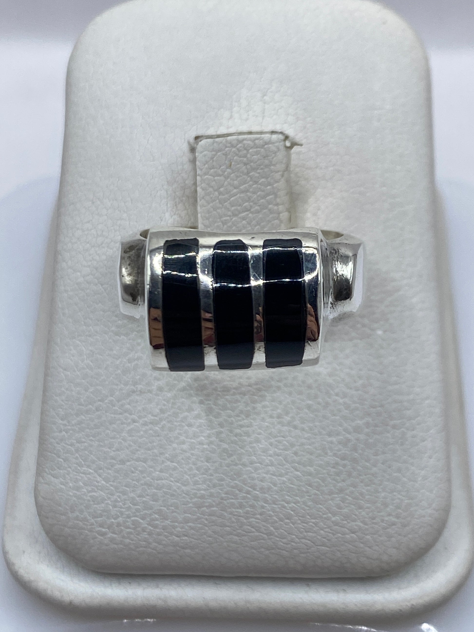 Anillo de plata .925 con tres franjas de ónix negro en la mano de una mujer