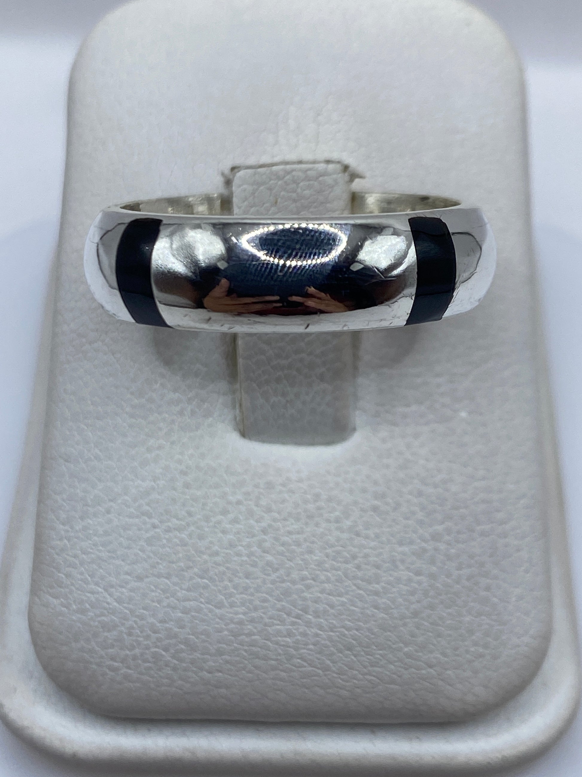 Anillo de plata .925 con piedra negra engastada, vista frontal sobre banda pulida
