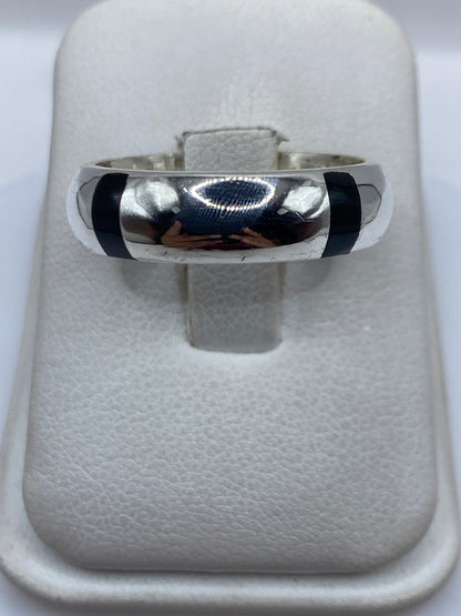 Anillo de plata .925 con piedra negra engastada, vista frontal sobre banda pulida