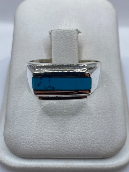 Anillo de plata con turquesa azul cielo en bandas escalonadas, visto de frente en estuche blanco