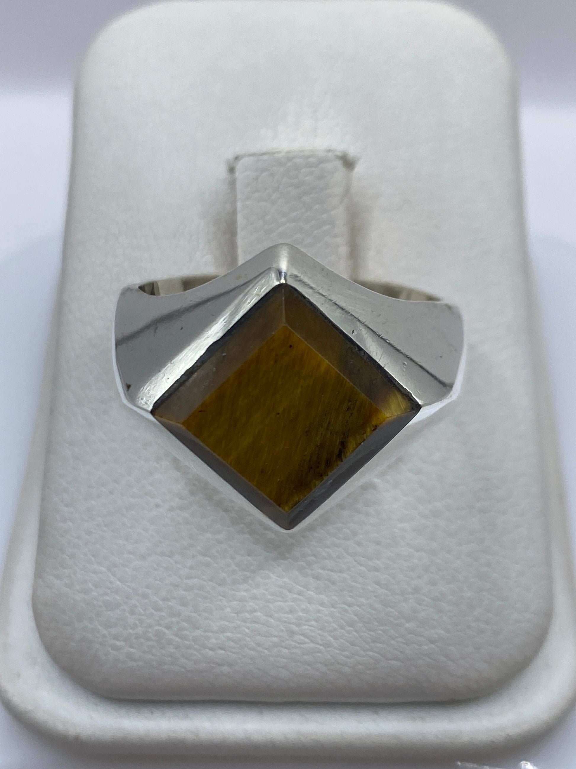 Anillo de plata .925 con piedra cafe engastada a mano, vista frontal sobre fondo blanco