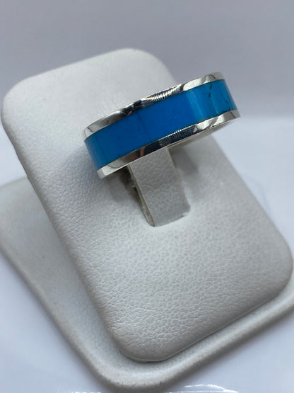 Detalle lateral del anillo mostrando el engaste de turquesa y el pulido de la plata .950