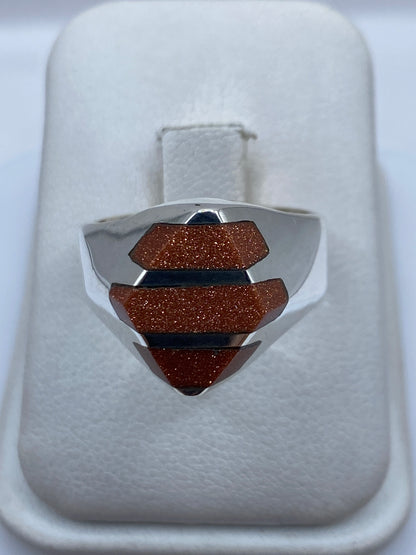 Anillo de plata escalonado con piedra incrustada visto desde arriba en caja blanca