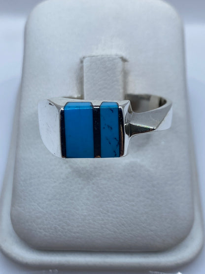 Anillo de plata .925 con turquesa azul cielo engastada, vista frontal sobre anillo blanco
