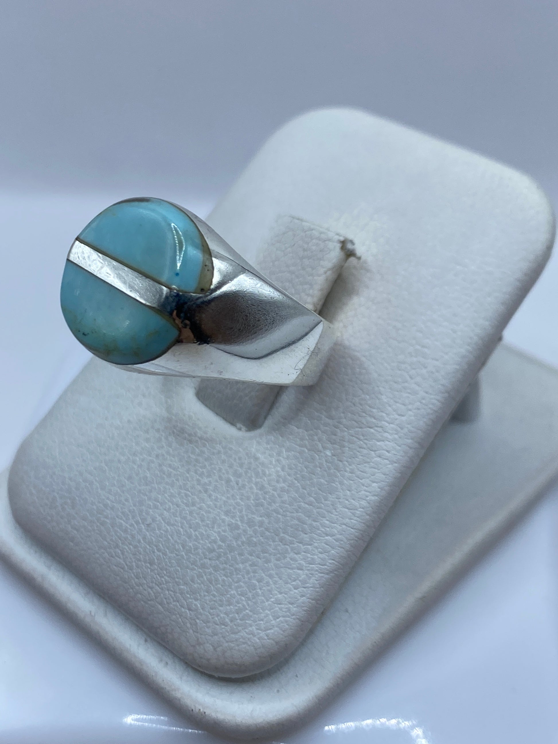 Detalle lateral del anillo mostrando el engaste a mano de la turquesa en plata pulida