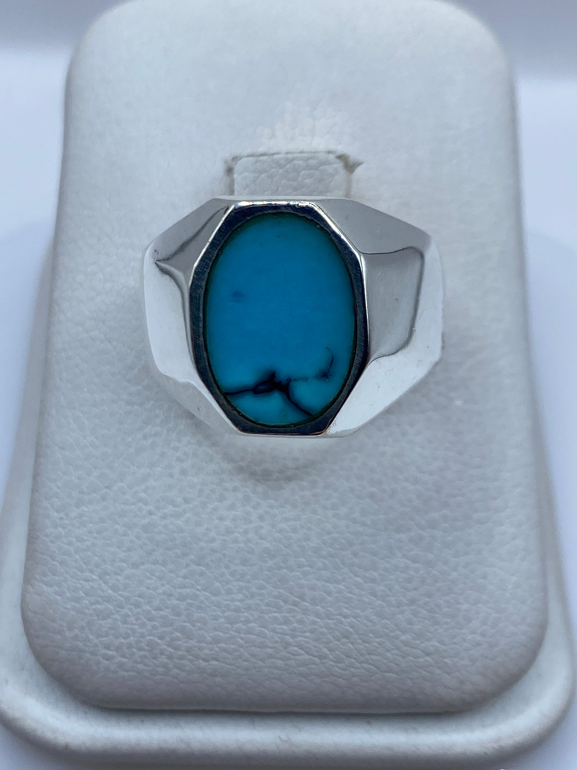 Anillo de plata con turquesa azul cielo engastada, visto desde arriba sobre fondo blanco