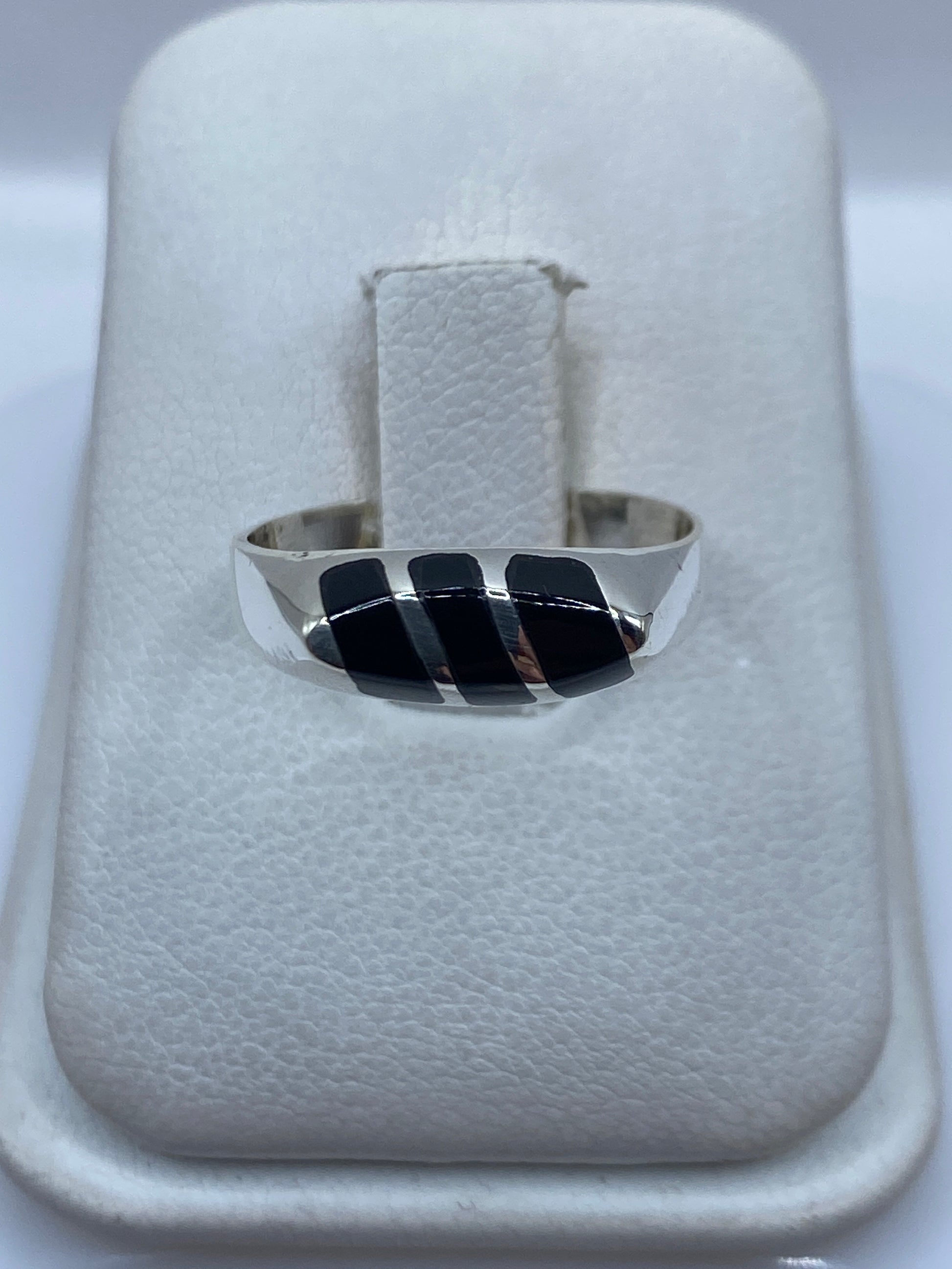 Anillo de plata con tres piedras de ónix negro engastadas, sobre estuche blanco