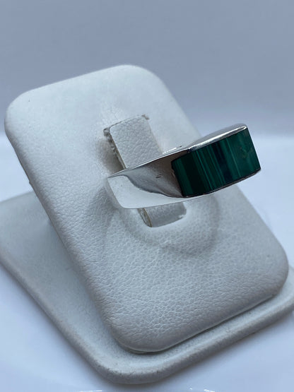 Anillo de plata malaquita verde en dedo de hombre, mostrando el peso y presencia