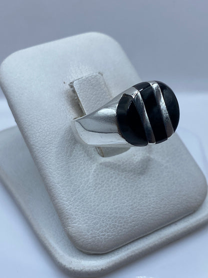 Vista frontal del anillo mostrando el engaste de ónix negro y la banda de plata