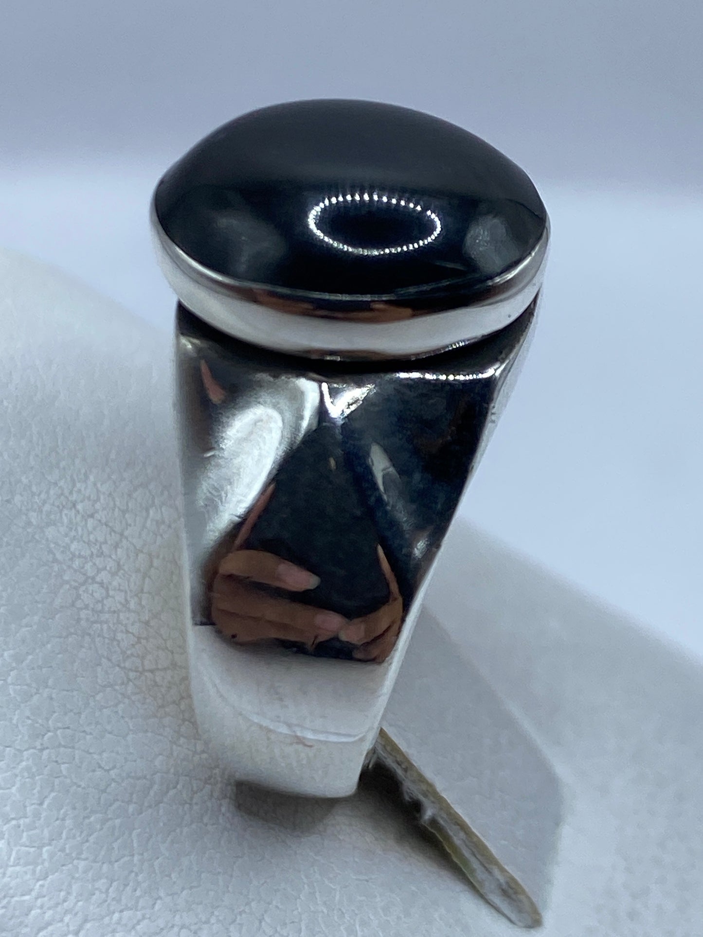 Detalle del ónix negro pulido reflejando la luz en el anillo