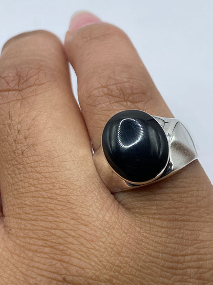 Anillo en el dedo mostrando el contraste entre la plata y la piedra negra