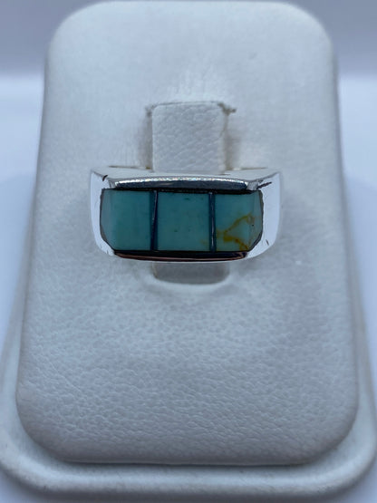 Anillo de plata .925 con tres bloques de turquesa azul cielo engastados en línea, sobre fondo blanco