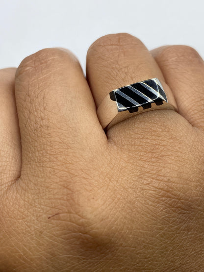 Anillo de ónix y plata sobre fondo blanco en posición horizontal