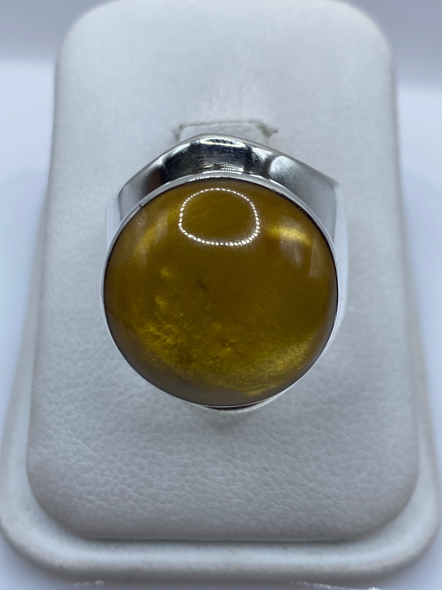 Anillo de plata .925 con piedra café engastada, visto desde arriba en estuche