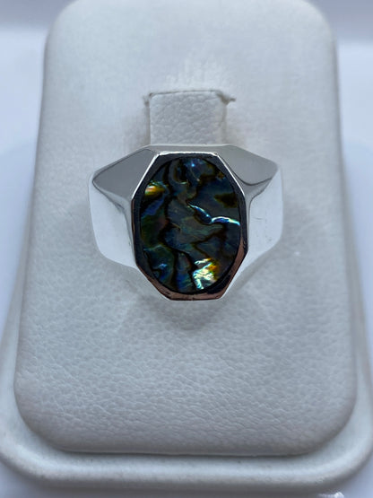 Anillo de plata .925 con piedra oscura engastada, vista frontal sobre almohadilla blanca