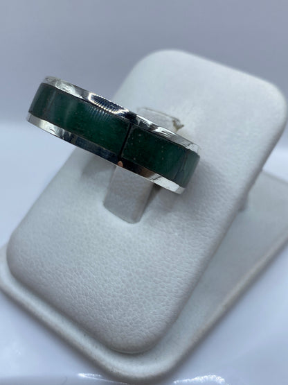 Detalle lateral del anillo mostrando el engaste a mano y la profundidad de la piedra verde