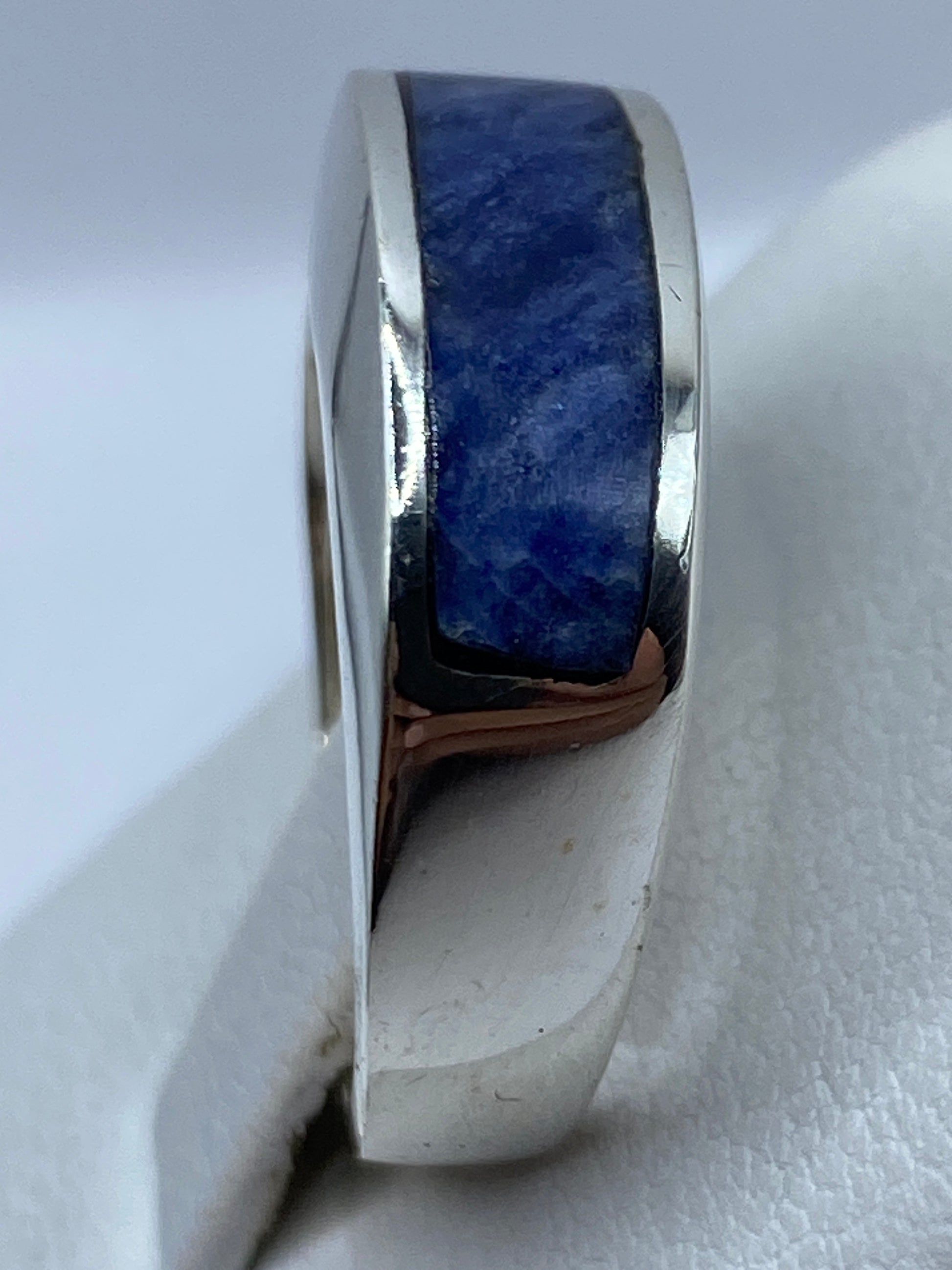 Anillo en la mano mostrando el color azul profundo de la piedra