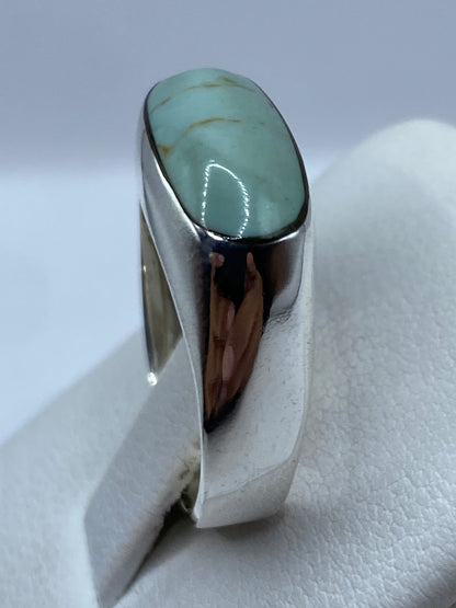 Detalle del anillo en la mano mostrando el color azul cielo de la piedra