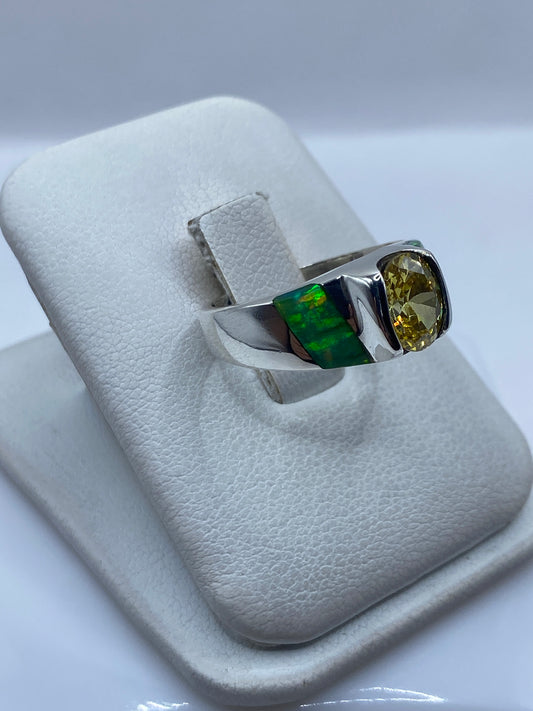 Vista lateral del anillo combinado con ópalo de fuego y perfiles verdes de incrustación