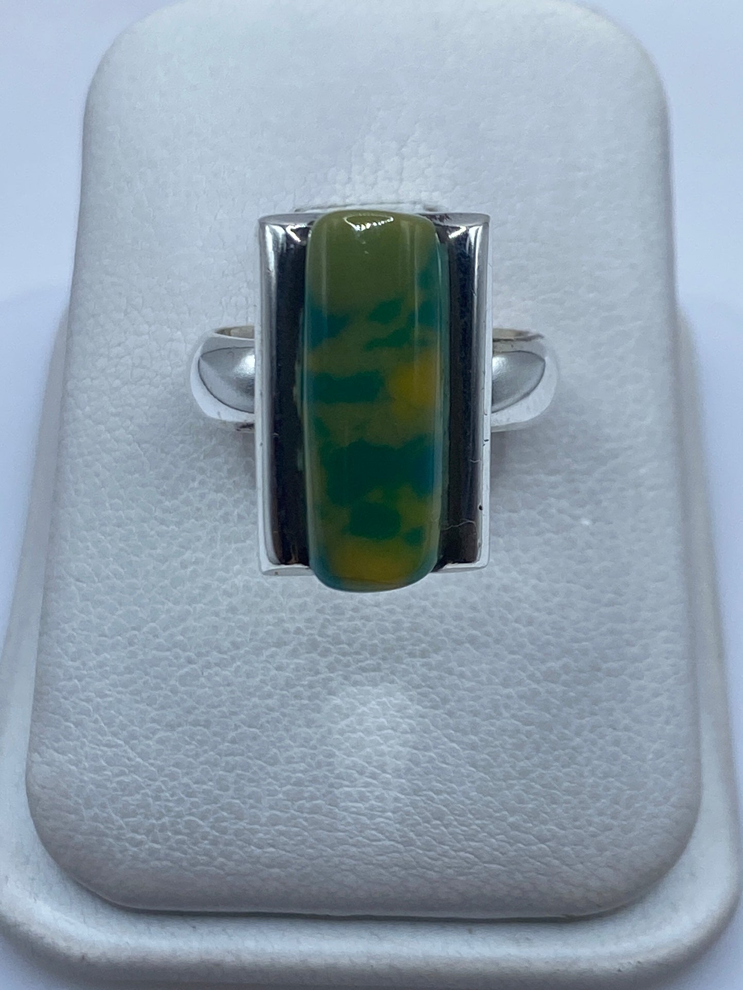 Anillo de plata .925 con piedra amarilla engastada, visto de frente en estuche blanco